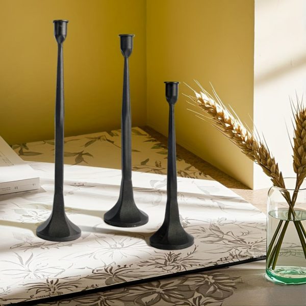 Trois bougeoirs noirs au design brut